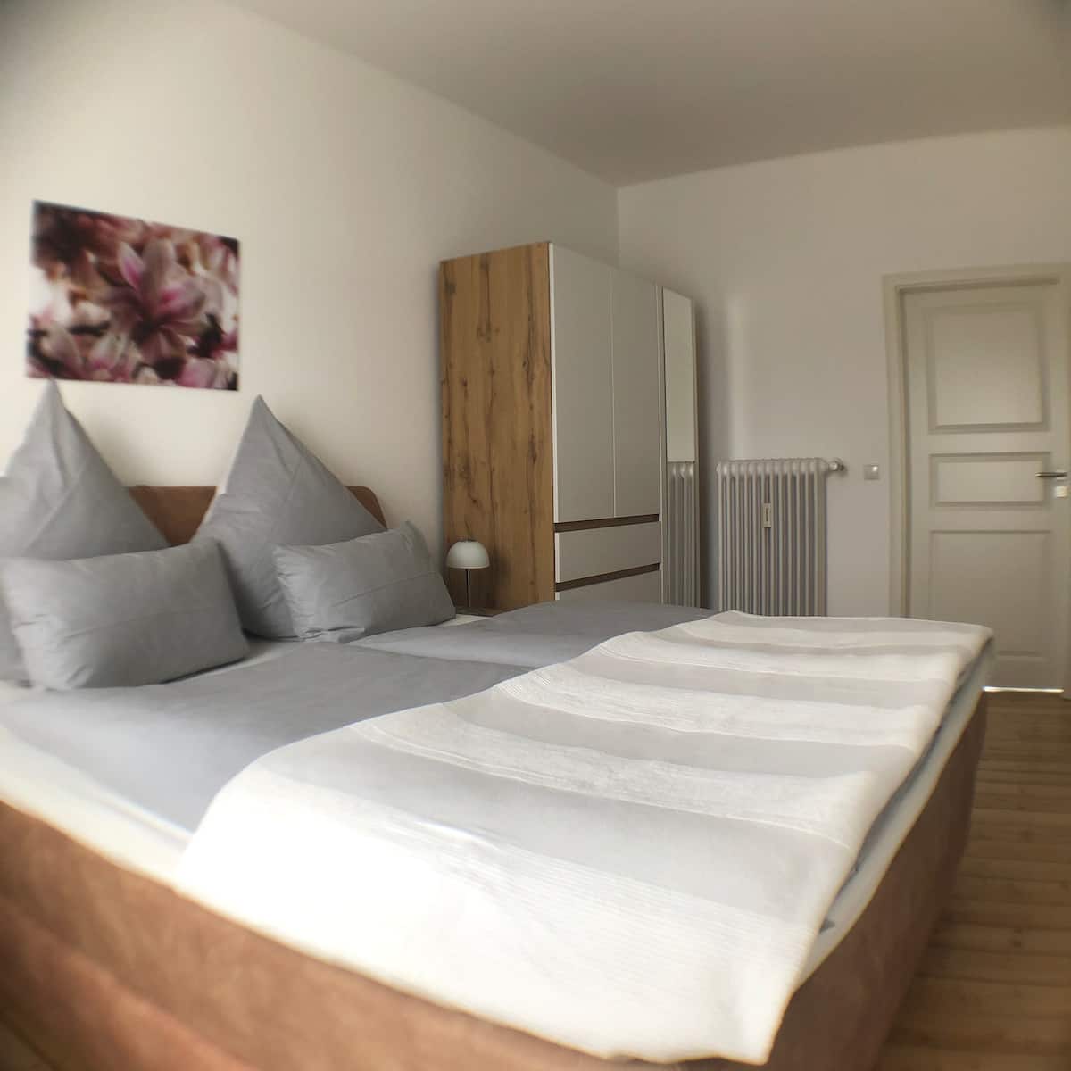 Doppelbett mit Hotelwäsche und Eichenschrank