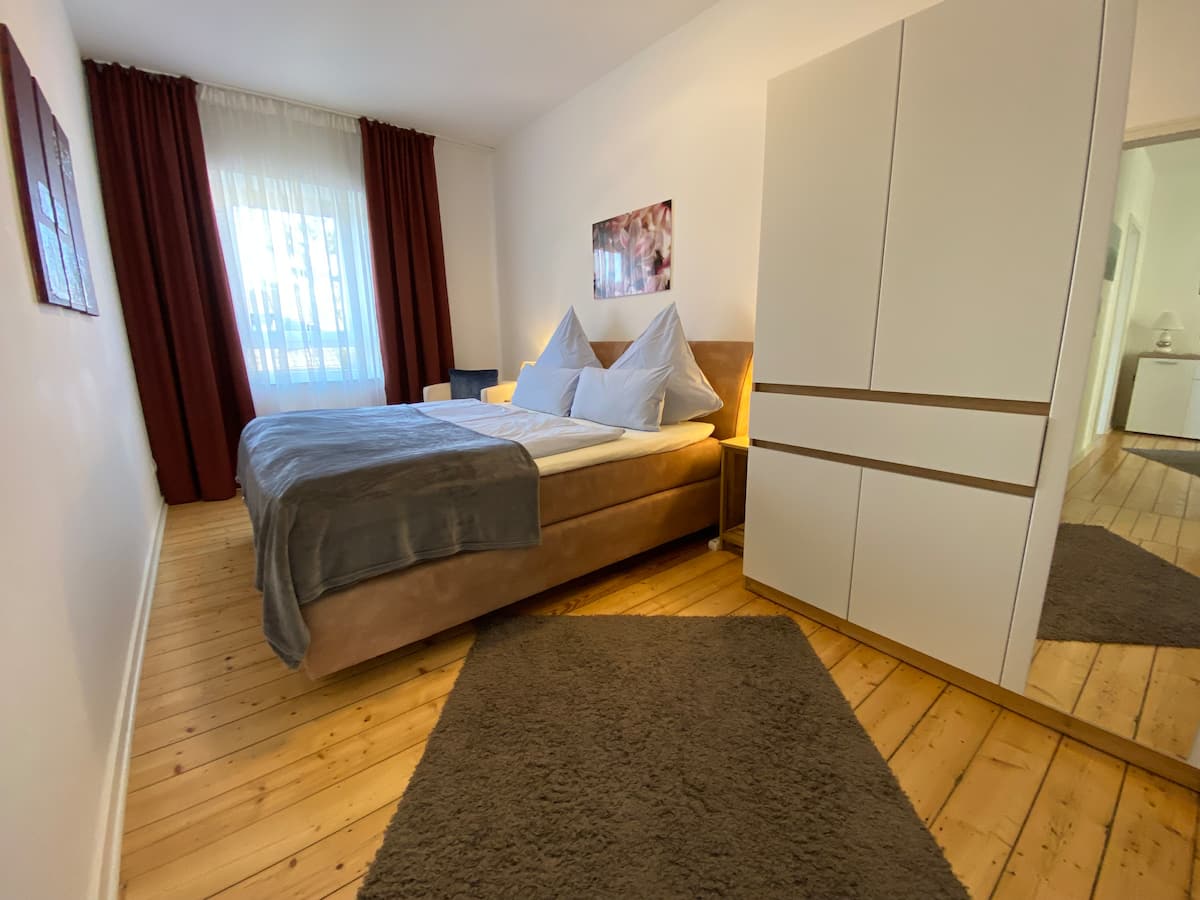 Schlafzimmer mit warmen Holzboden und Kleiderschrank